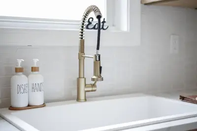 a kitchen sink with a faucet and two bottles at The Perfect Pass-HOF Village Escape in Canton