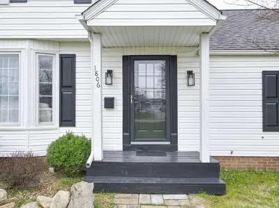 a white house with a black front door at The Perfect Pass-HOF Village Escape in Canton