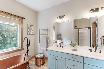 a bathroom with two sinks and a tub and a window at Some Kind of Wonderful-Escape Near Seneca Lake in Senecaville
