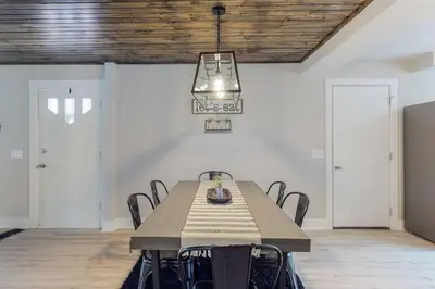 a dining room with a table with chairs and a chandelier at Steps to the HOF-Football Fans Dream Stay in Canton