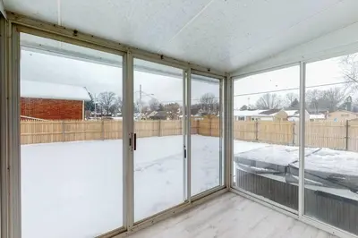an empty room with sliding glass doors with snow at Steps to the HOF-Football Fans Dream Stay in Canton