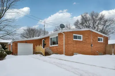 a brick house in the snow on a snowy street at Steps to the HOF-Football Fans Dream Stay in Canton