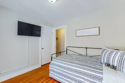 a bedroom with a bed and a flat screen tv at Steps to the HOF-Football Fans Dream Stay in Canton