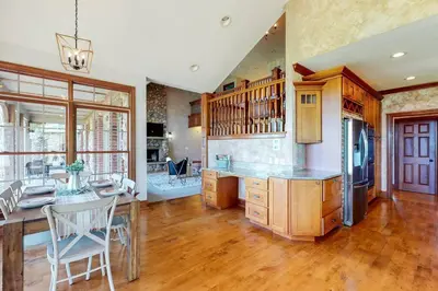 a large kitchen with wooden floors and a dining room at Grace and Grandeur-The Stables Estate in North Lawrence