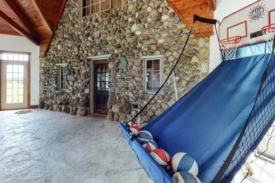 a house with a basketball hoop in front of a stone wall at Grace and Grandeur-The Stables Estate in North Lawrence