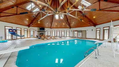 a large indoor pool with a gym with a slide at Grace and Grandeur-The Stables Estate in North Lawrence