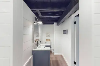 a bathroom with a sink and a mirror at The Playmakers Funhouse-HOF Village in Canton