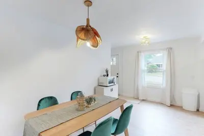 a dining room with a table and green chairs at The Playmakers Funhouse-HOF Village in Canton