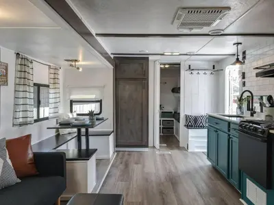 a kitchen and living room with a couch in a tiny house at Wildflower Wanderlust-Glamping st 1885 Farms in Navarre