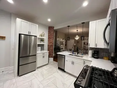 a kitchen with white cabinets and a stainless steel refrigerator at 2 BR Totally Renovated and Chic in Columbus