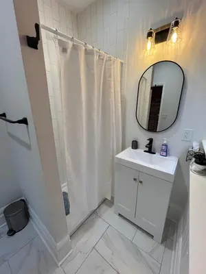 a white bathroom with a sink and a mirror at 2 BR Totally Renovated and Chic in Columbus
