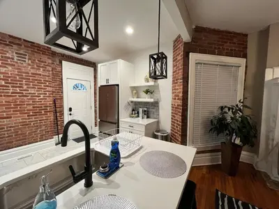 a kitchen with a sink and a brick wall at 2 BR Totally Renovated and Chic in Columbus