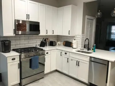 a kitchen with white cabinets and a stove top oven at Big Brick 2 Bedroom apartment in Victorian Village in Columbus