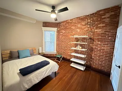 a bedroom with a brick wall and a bed at Big Brick 2 Bedroom apartment in Victorian Village in Columbus