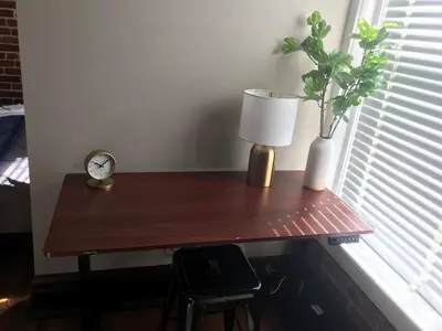 a wooden table with a lamp and a plant on it at Big Brick 2 Bedroom apartment in Victorian Village in Columbus