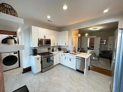 a large kitchen with white cabinets and appliances at Big Brick 2 Bedroom apartment in Victorian Village in Columbus