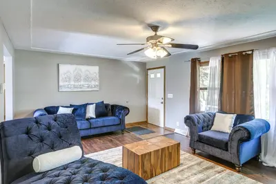 a living room with two blue couches and a ceiling fan at Lake Erie Family Getaway in Amherst Pets Welcome! in Amherst