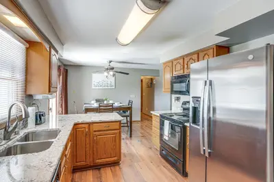 a kitchen with a stainless steel refrigerator and wooden cabinets at Lake Erie Family Getaway in Amherst Pets Welcome! in Amherst