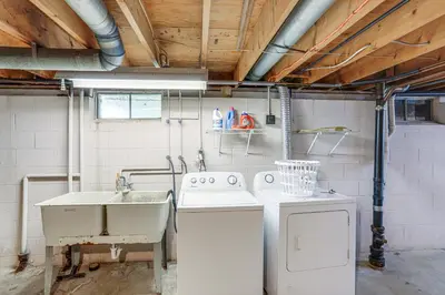 a kitchen with a sink and a washing machine at Lake Erie Family Getaway in Amherst Pets Welcome! in Amherst