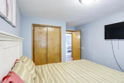 a bedroom with a bed and a flat screen tv at Lake Erie Family Getaway in Amherst Pets Welcome! in Amherst