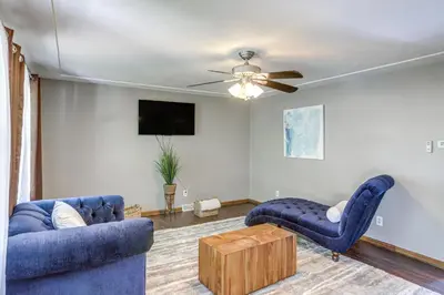 a living room with two blue chairs and a ceiling fan at Lake Erie Family Getaway in Amherst Pets Welcome! in Amherst