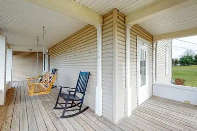a rocking chair on the porch of a house at The Farmhouse at 1885-Where Past Meets Present in Navarre