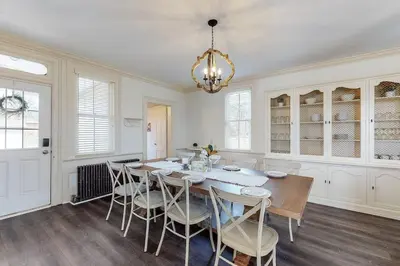 a dining room with a table and chairs and a chandelier at The Farmhouse at 1885-Where Past Meets Present in Navarre