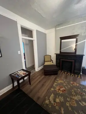 a living room with a fireplace and a chair at Second floor deluxe studio in Cincinnati