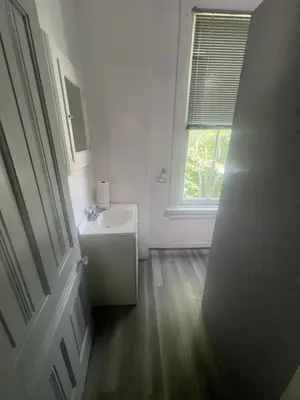 a white bathroom with a sink and a window at Second floor deluxe studio in Cincinnati