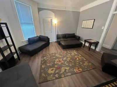 a living room with black leather furniture and a rug at Second floor deluxe studio in Cincinnati