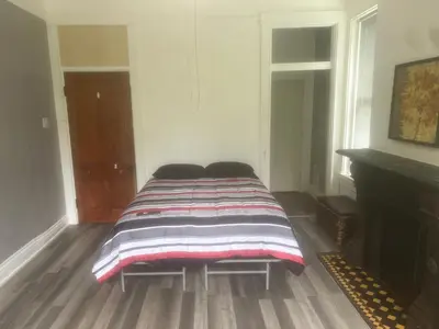a bed in a room with a striped blanket on it at Second floor deluxe studio in Cincinnati