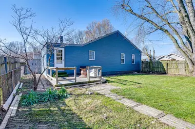 a blue house with a fence in a yard at Cozy Muncie Home Near Downtown in Muncie
