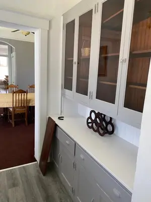 a kitchen with white cabinets and a counter with a table at Second floor standard studio private room in Cincinnati