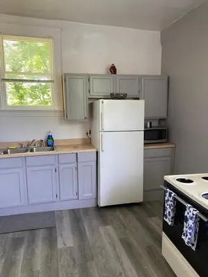 a kitchen with white cabinets and a white refrigerator at Second floor standard studio private room in Cincinnati