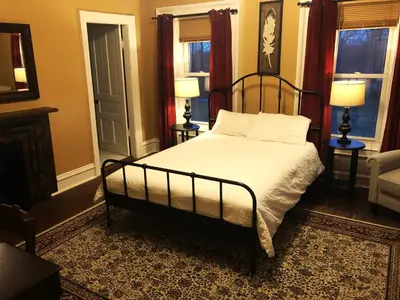 a bedroom with a bed and two lamps and a chair at The Vine Bed & Breakfast, LLC in Dundee