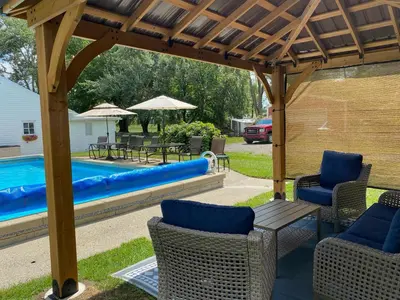a wooden pergola with chairs and a pool at The Vine Bed & Breakfast, LLC in Dundee