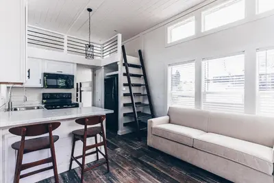 a living room with a couch and a kitchen at Cincinnati Camp Cedar in Mason