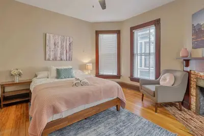 a bedroom with a bed and a chair and a fireplace at 4 Bed Duplex near Goodale Park in Columbus