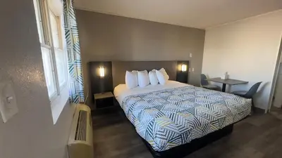 a hotel room with a bed with pillows on it at Botkins Motel