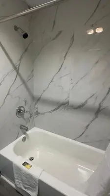 a bathroom with a white sink and marble walls at Botkins Motel