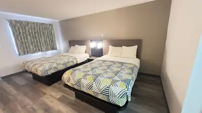 a hotel room with two beds and a window at Botkins Motel