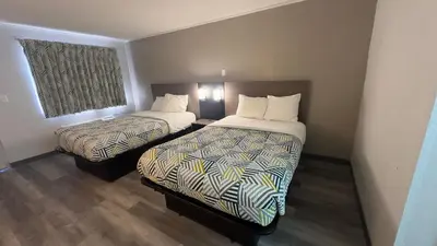 a hotel room with two beds and a window at Botkins Motel