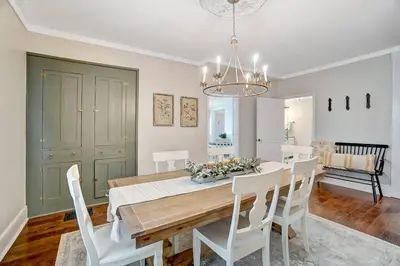 a dining room with a table and white chairs at General Mitchel Historic Home in Downtown Lebanon in Lebanon