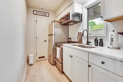a kitchen with white cabinets and a sink and a window at Cozy Meyers Lake Townhome Near Hall of Fame! in Canton