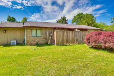 a house with a fence and a yard at Cozy Meyers Lake Townhome Near Hall of Fame! in Canton