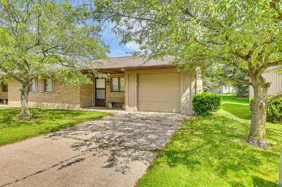 a house with a driveway and trees in front of it at Cozy Meyers Lake Townhome Near Hall of Fame! in Canton