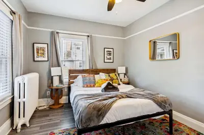 a bedroom with a bed and two windows at Tiny Taco House in Lakewood