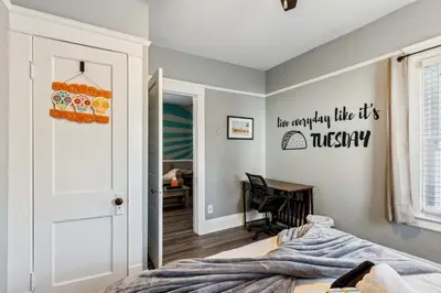 a bedroom with a bed and a hallway with a desk at Tiny Taco House in Lakewood