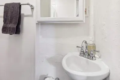 a white bathroom with a sink and a mirror at Tiny Taco House in Lakewood