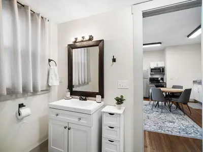 a white bathroom with a sink and a mirror at Carriage Manor - Sun Soaked 1BR - Close to CCF in Cleveland